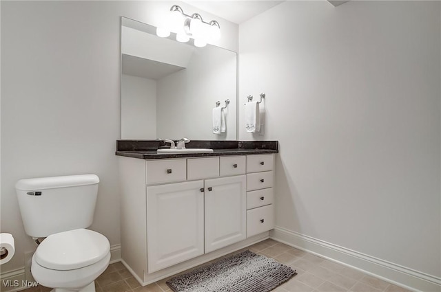 bathroom with toilet, baseboards, and vanity