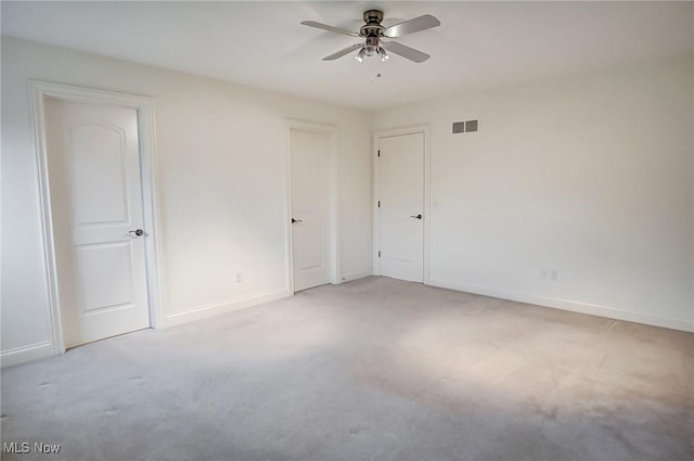 unfurnished room featuring light carpet, baseboards, visible vents, and ceiling fan