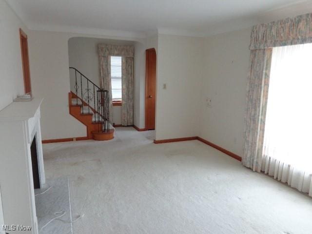 interior space with carpet, stairway, arched walkways, and baseboards