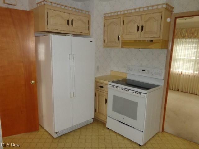 kitchen with white appliances, under cabinet range hood, light floors, and wallpapered walls