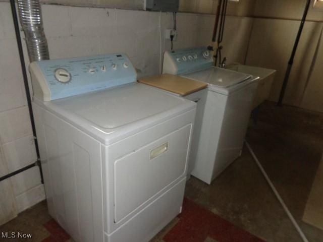 laundry area with concrete block wall, laundry area, and washer and dryer