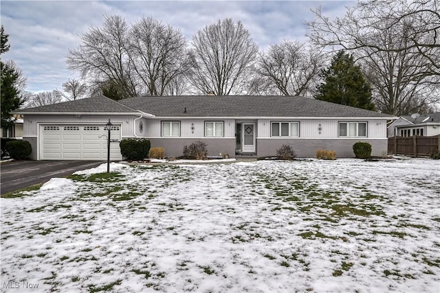 ranch-style home featuring a garage, aphalt driveway, and fence