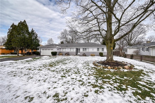 single story home featuring a garage, driveway, and fence