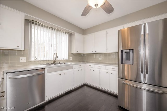 kitchen featuring a sink, white cabinets, light countertops, appliances with stainless steel finishes, and decorative backsplash