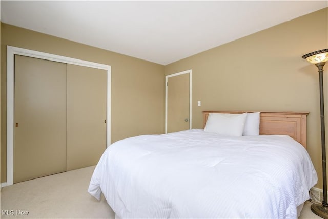 bedroom featuring a closet and light colored carpet