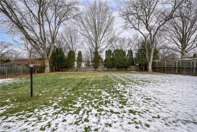 yard covered in snow with a fenced backyard