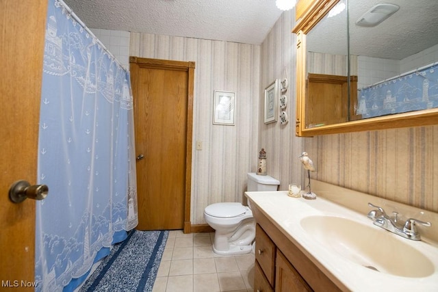 full bathroom featuring toilet, vanity, a textured ceiling, tile patterned flooring, and wallpapered walls