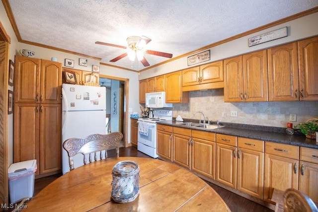 kitchen featuring white appliances, brown cabinetry, a sink, and crown molding