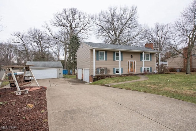 bi-level home with a detached garage, an outdoor structure, a chimney, and a front lawn