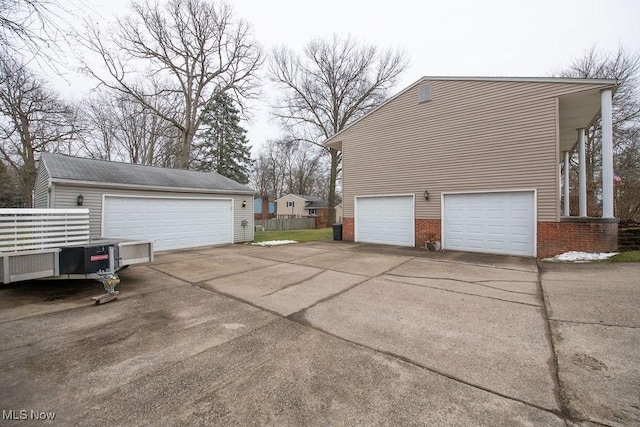 view of side of property featuring an outbuilding, brick siding, and fence