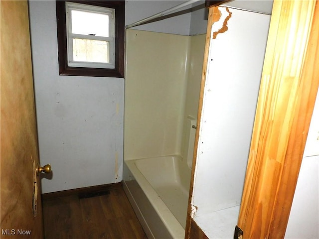 full bathroom with a shower, a washtub, baseboards, and wood finished floors