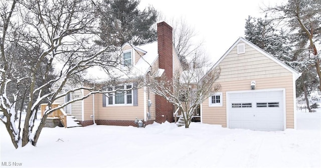 view of front of house with entry steps, a chimney, and an attached garage