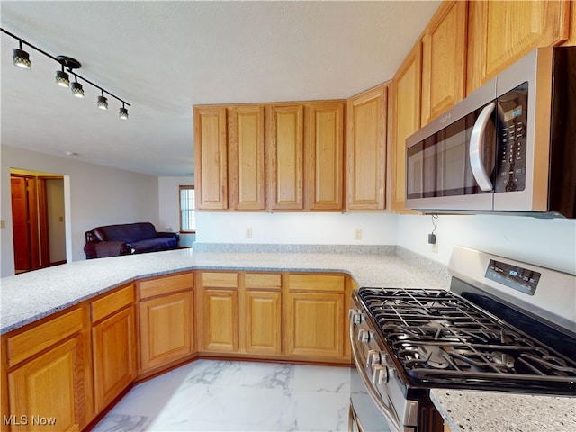 kitchen featuring appliances with stainless steel finishes, marble finish floor, open floor plan, and light stone countertops