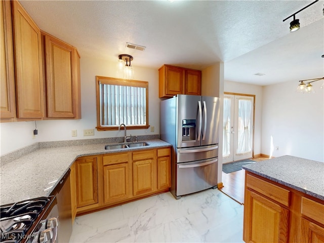 kitchen featuring stainless steel appliances, a sink, visible vents, marble finish floor, and french doors