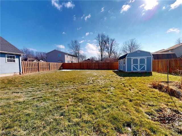 view of yard featuring an outbuilding, a shed, and a fenced backyard