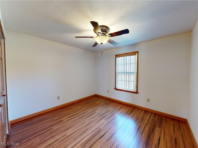 unfurnished room featuring a ceiling fan, a textured ceiling, baseboards, and wood finished floors