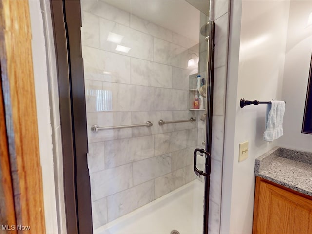 full bath with a stall shower and vanity