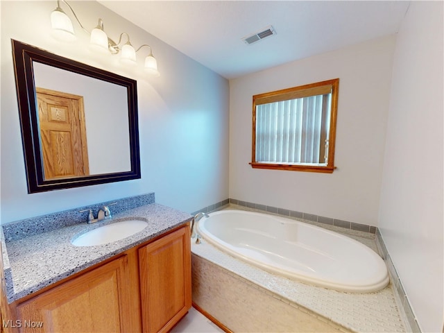 full bath with a garden tub, visible vents, and vanity