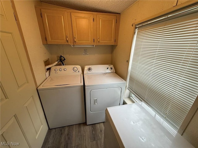 laundry room featuring cabinet space, a textured ceiling, washer and dryer, and wood finished floors