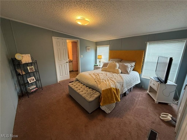 bedroom with a textured ceiling, carpet flooring, visible vents, and crown molding