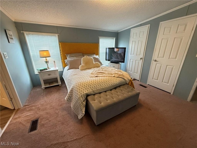 bedroom featuring a textured ceiling, carpet floors, visible vents, and crown molding