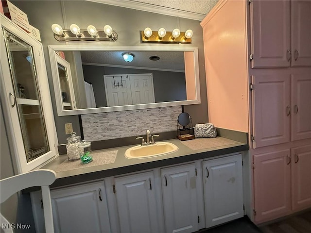 bathroom with a textured ceiling, ornamental molding, backsplash, and vanity