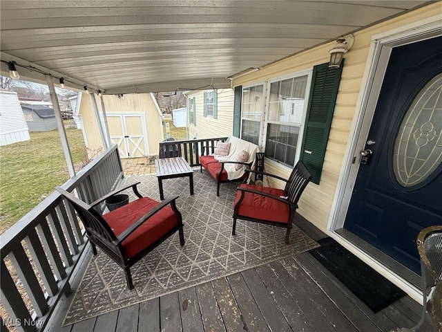 wooden deck featuring a yard, an outdoor structure, an outdoor hangout area, and a storage unit