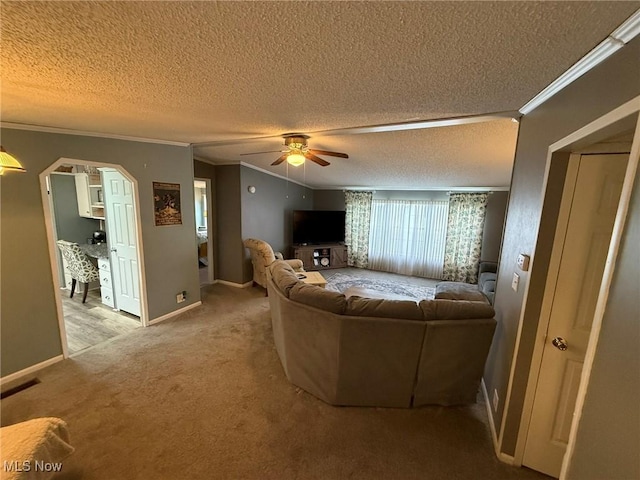 living room with carpet floors, crown molding, a textured ceiling, and ceiling fan