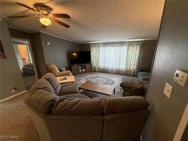 living area with ceiling fan, vaulted ceiling, a textured ceiling, crown molding, and carpet floors