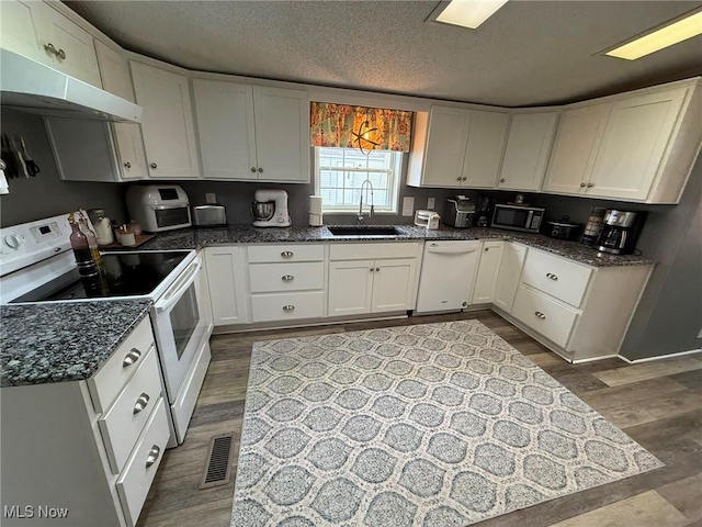 kitchen featuring dark wood-style flooring, white cabinetry, a sink, a textured ceiling, and white appliances