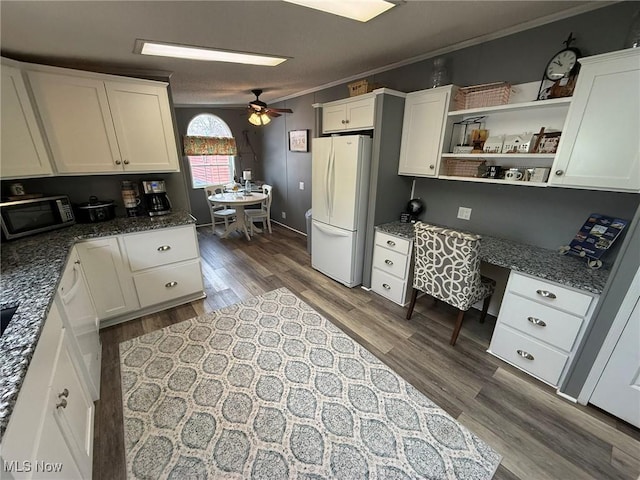 kitchen with dark wood-style floors, ornamental molding, freestanding refrigerator, white cabinets, and built in study area