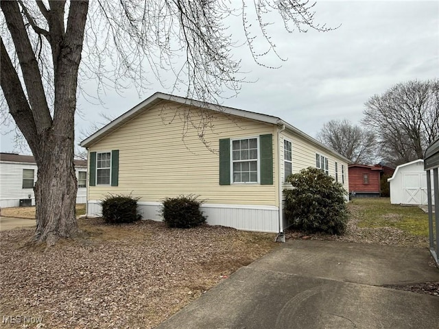 view of property exterior with an outbuilding and a shed