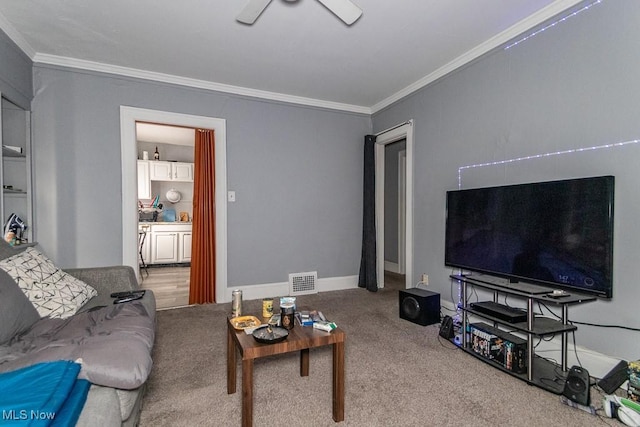 living area with baseboards, carpet flooring, a ceiling fan, and crown molding