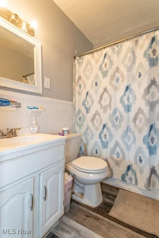 full bath featuring toilet, wood finished floors, and vanity