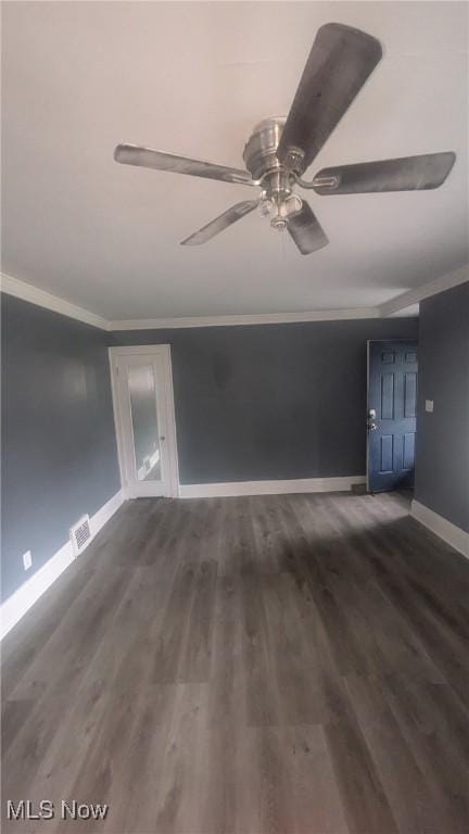 unfurnished room with crown molding, visible vents, ceiling fan, wood finished floors, and baseboards