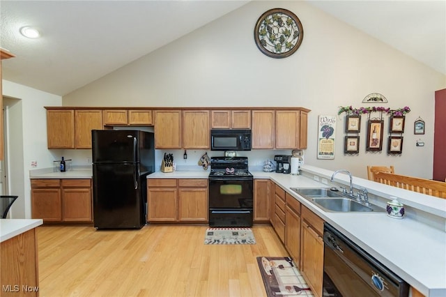 kitchen featuring brown cabinetry, light countertops, a sink, and black appliances