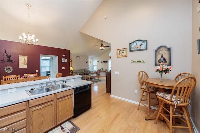 kitchen featuring dishwasher, light wood-style flooring, vaulted ceiling, a sink, and ceiling fan with notable chandelier