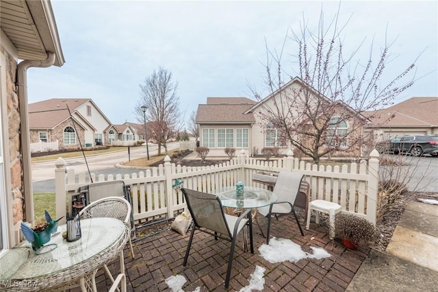 view of patio featuring a residential view, outdoor dining area, and fence