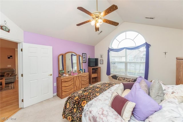 bedroom featuring visible vents, vaulted ceiling, light carpet, and ceiling fan