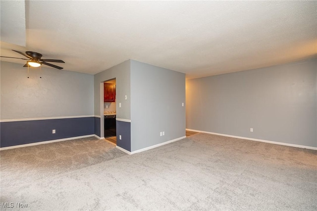 spare room featuring carpet floors, a textured ceiling, baseboards, and a ceiling fan