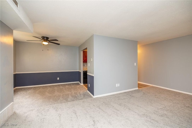 empty room with carpet floors, ceiling fan, and baseboards