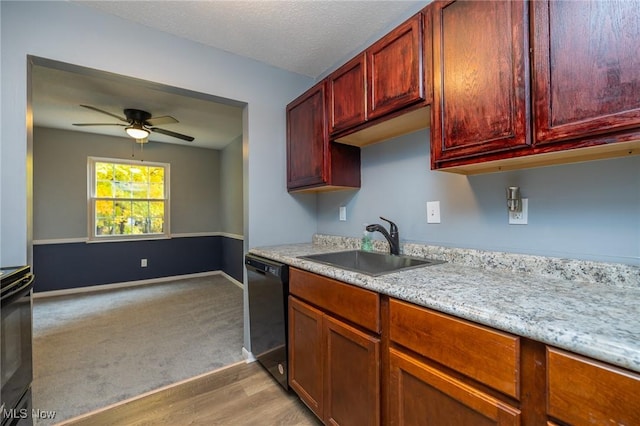 kitchen featuring a sink, baseboards, black dishwasher, range, and reddish brown cabinets