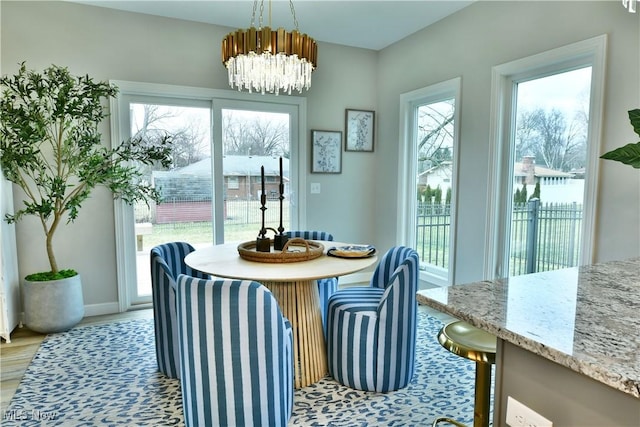 dining room featuring a chandelier, light wood-style floors, and baseboards