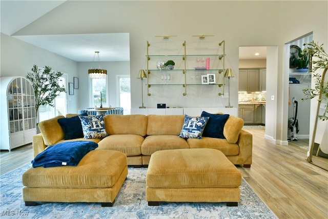 living room with a chandelier, baseboards, and wood finished floors