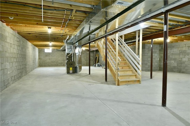 unfinished below grade area featuring stairway and heating unit