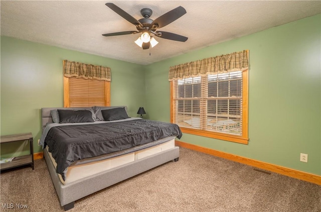 bedroom featuring carpet floors, visible vents, a ceiling fan, a textured ceiling, and baseboards