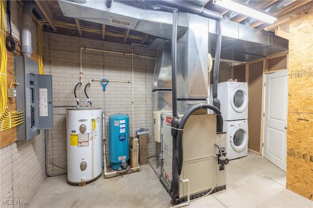 utility room with water heater, visible vents, and stacked washer / dryer