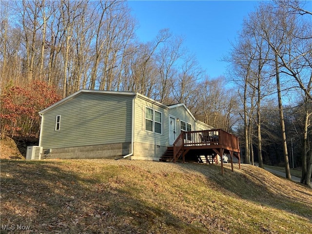 view of home's exterior featuring crawl space, a lawn, and a deck