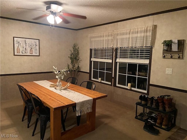 dining area featuring a ceiling fan, a textured ceiling, and ornamental molding