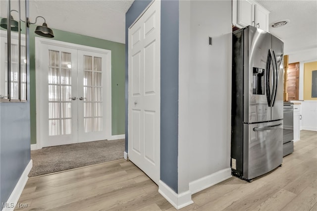 interior space with baseboards, french doors, and light wood-style floors